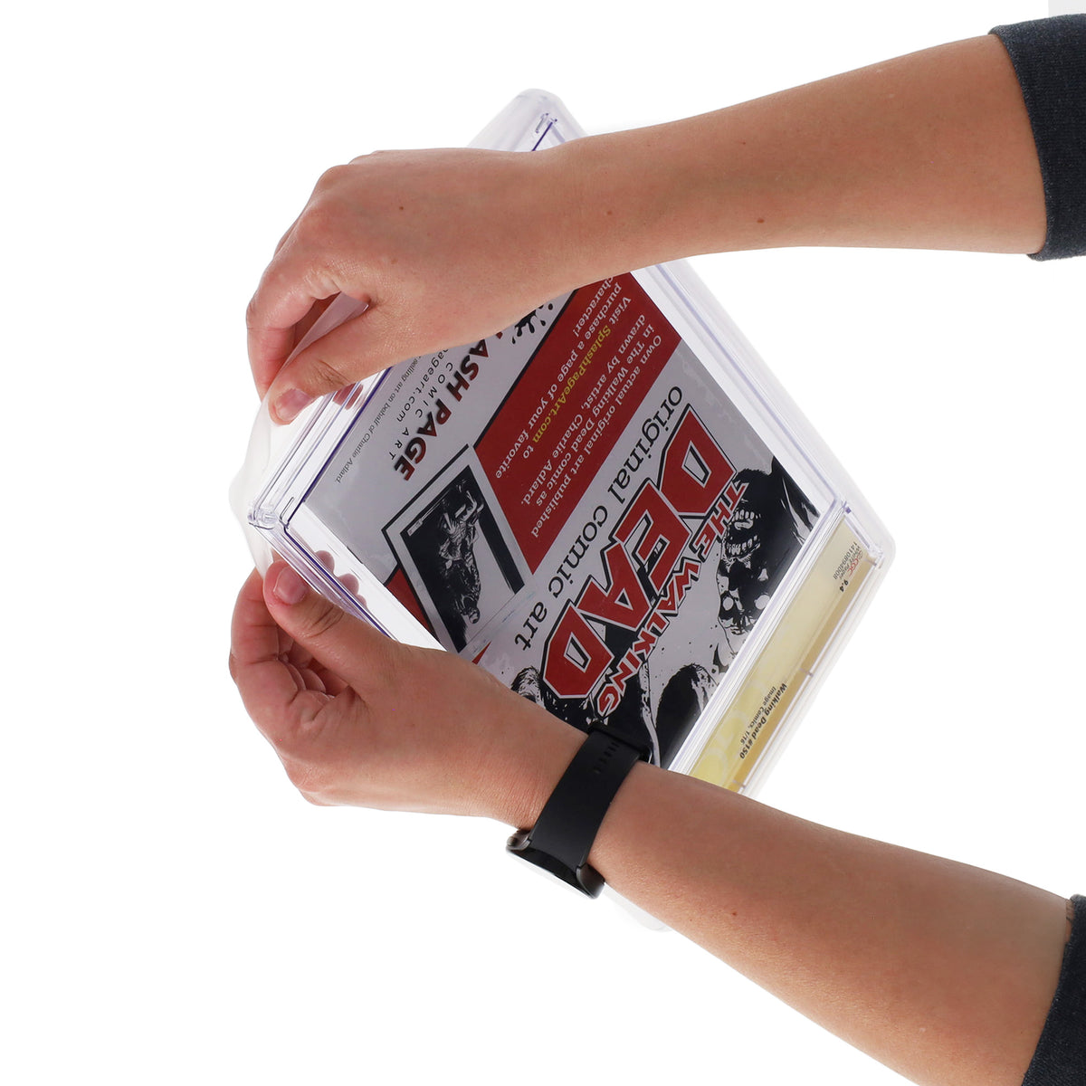 Hands fitting a translucent BCW bumper around a graded comic slab